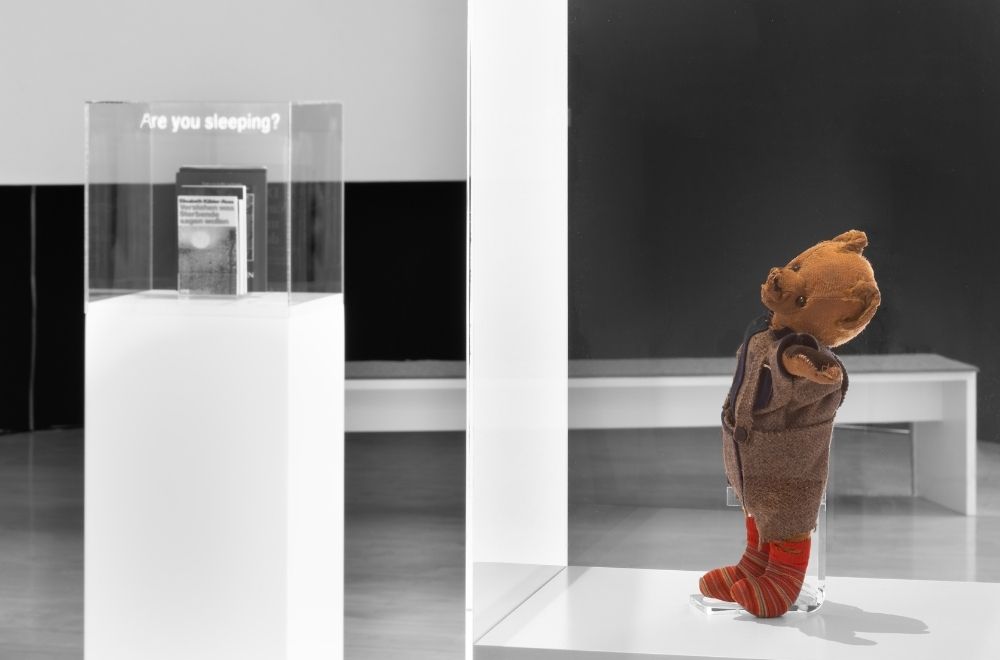 Ein abgenutzter, viel geliebter Teddybär in einem Museum. Er ist Teil einer Ausstellung über Trost.